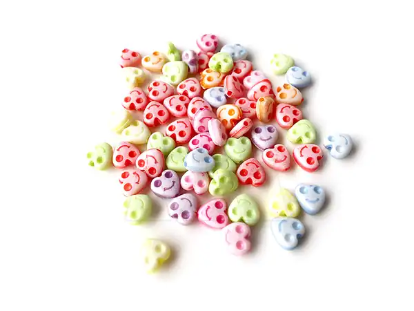 CUENTAS DE PLASTICO CORAZON CON CARITAS 8MM X 125GR